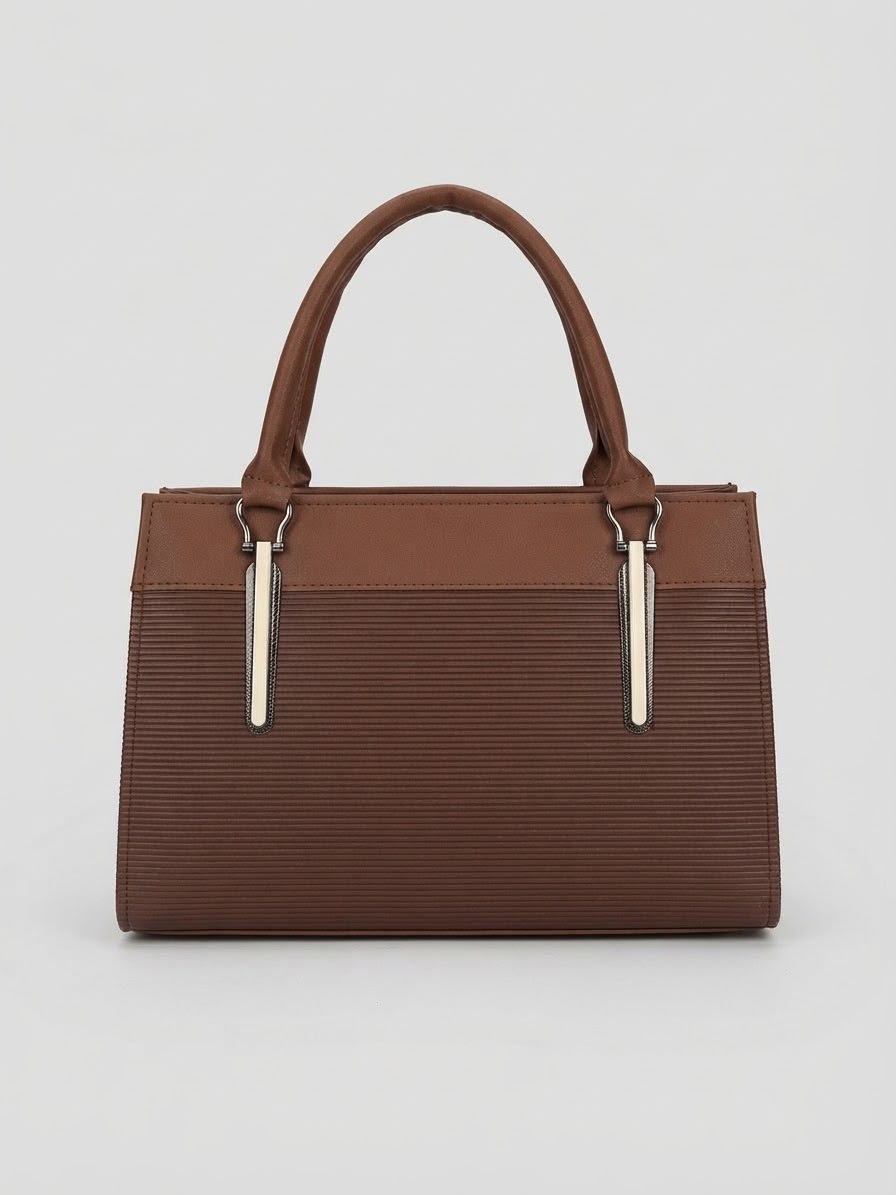 A back view of a brown structured handbag with top handles and vertical silver hardware accents.