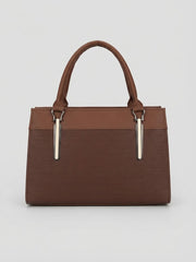 A back view of a brown structured handbag with top handles and vertical silver hardware accents.