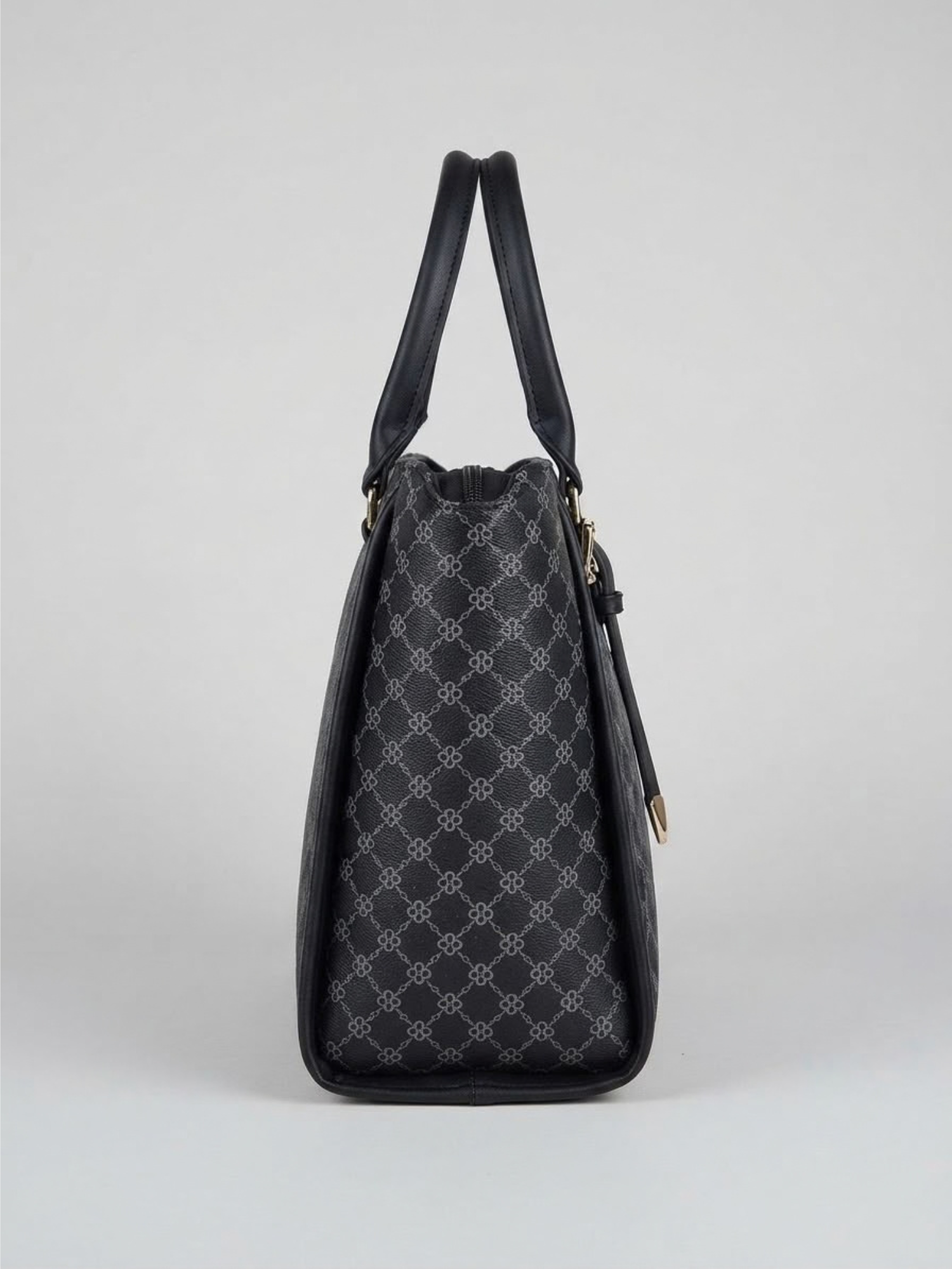 Side angle profile of the structured black tote bag displaying its gusset width and upright dual handles.
