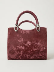 Black view of a burgundy velvet handbag.