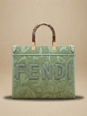 Front view of a sage green Fendi tote bag with an embossed logo pattern and tortoiseshell top handles.