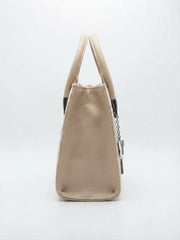 Side view of the beige velvet handbag showing gold leather trim.