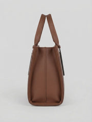 A side profile view showing the depth of the brown structured handbag.